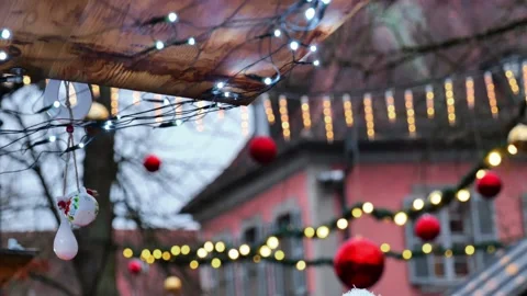 Garlands and red balls on trees in winter city on houses background. Stock Footage 313750163
