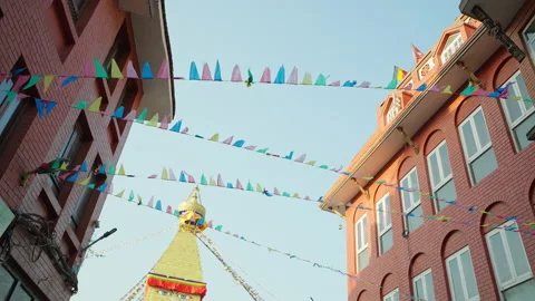 Garlands of multicolor flags flap under blue sky on street near Swayambhunath Stock Footage 167490177
