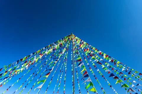 Garlands of multicolored triangular flags on blue sky background. Copy space Stock Photos