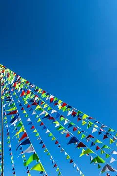 Garlands of multicolored triangular flags on blue sky background. Copy space Stock Photos