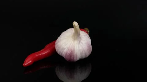 Garlic and pepper on black background Stock Footage 220358367