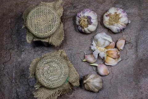 Garlic and spices on a stone table in the kitchen. Healthy and fragrant clove Stock Photos