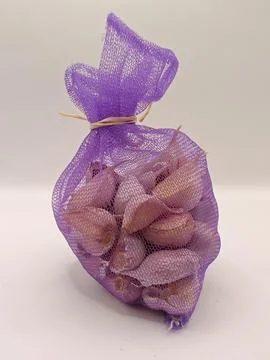 Garlic in a bag on a white background close up Stock Photos
