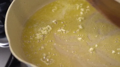 Garlic being stirred on a pan Stock Footage 128638225