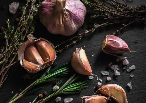 Garlic on a black background. Nuts, cheese, rosemary and thyme. Ingredients f Stock Photos