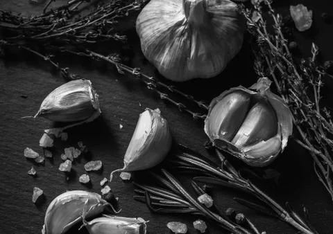 Garlic on a black background. Nuts, cheese, rosemary and thyme. Ingredients f Stock Photos