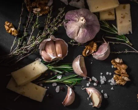 Garlic on a black background. Nuts, cheese, rosemary and thyme. Ingredients Stock Photos