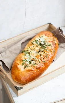 Garlic bread with cheese and herbs on wooden box, light grey background Stock Photos