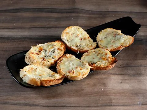Garlic bread, served over a rustic wooden background, selective focus Stock Photos