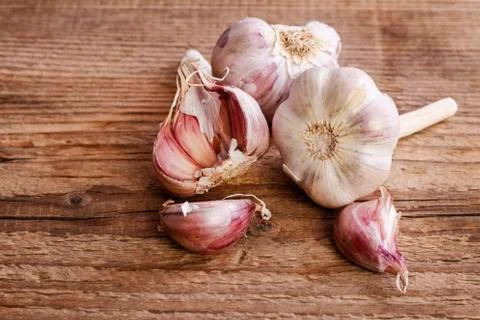 Garlic on brown wooden table. Stock Photos