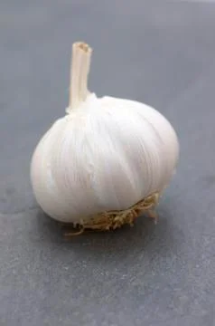 A garlic bulb on a slate surface Stock Photos