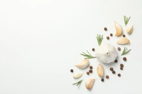 Garlic bulbs, slices, spice, parsley, rosemary on white background, top view. Stock Photos