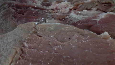 Garlic cloves fall on raw meat. Close-up Stock Footage 130489982