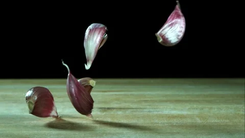 Garlic cloves falling and bouncing on table Stock Footage 327051861