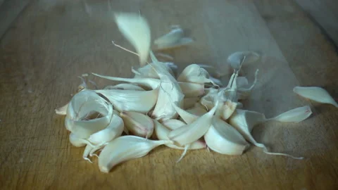 Garlic cloves falling in slow motion on wooden Stock Footage 131711176