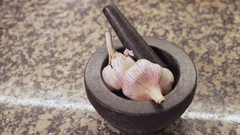 Garlic cloves rotating inside a mortar on a kitchen counter Stock Footage 331066841