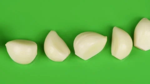 Garlic cloves in a row on green background. Top view. Stock Footage 163917558