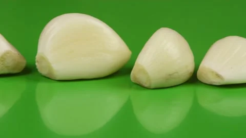 Garlic cloves in a row on green background. Stock Footage 163917708