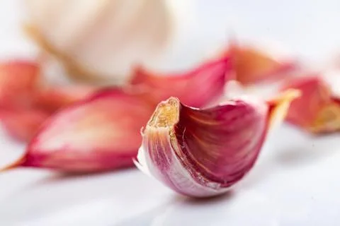 Garlic cloves on white background with kitchen knife Stock Photos