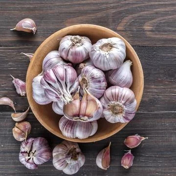Garlic cloves on a wooden vintage background. Stock Photos