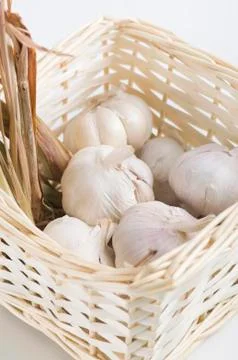 Garlic with dried lemon grass inside a rattan basket Stock Photos