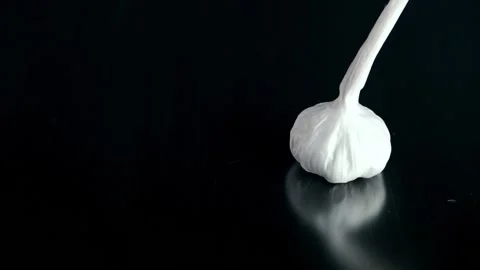 Garlic falling against black background 스톡 동영상 132917138
