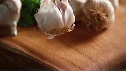 Garlic falls in front of the camera in slow motion on the wooden floor. Stock Footage 140514132