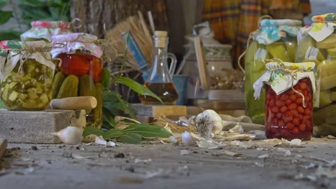 Garlic falls on the table in slow motion. Farm pickled vegetables in glass jars Stock Footage 250996462