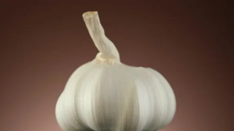 Garlic isolated on brown background, rotating Video stock 165090060