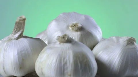 Garlic isolated rotating on green background Stock Footage 62332473