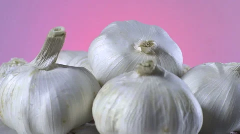 Garlic isolated rotating on pink background Video stock 62334107