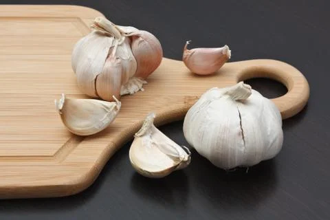 Garlic on  kitchen cutting board Stock Photos