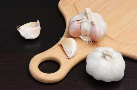 Garlic on kitchen cutting board Stock Photos