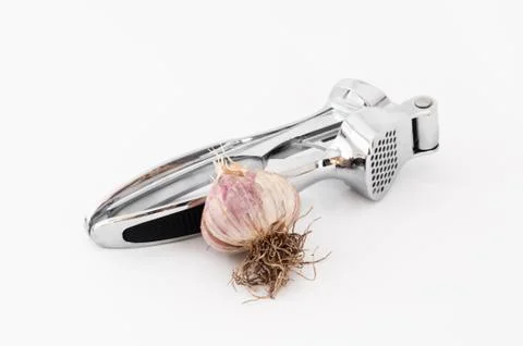 Garlic with a kitchen press Stock Photos