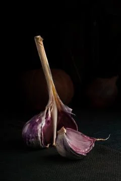 Garlic with one slice on the dark backround Stock Photos