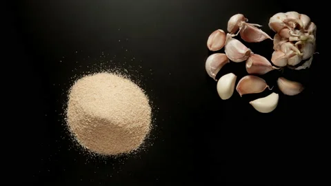 Garlic powder is piled up on the black table, stop motion Stock Footage 145931324