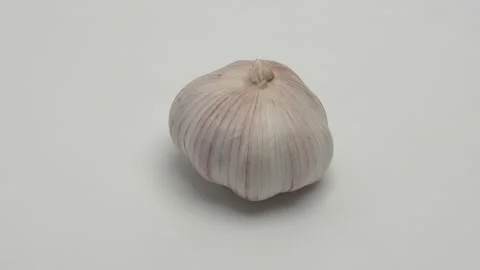 Garlic rotates on a white background. Stockbeeldmateriaal 265967025