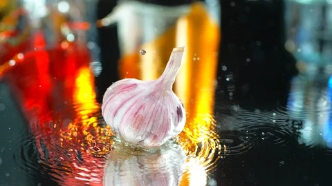 Garlic slowly falls on a table in the water. SLOW MOTION , 4K, SLOW FALLING Stock Footage 114965196