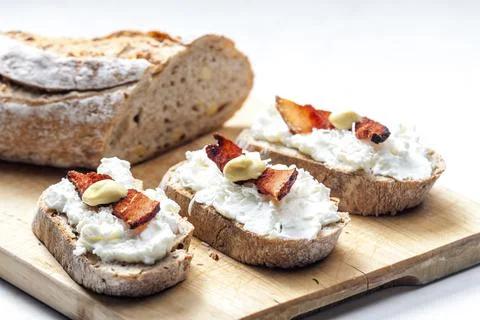 Garlic spread on slice of bread served with bacon, grated cheese and mustard Stock Photos