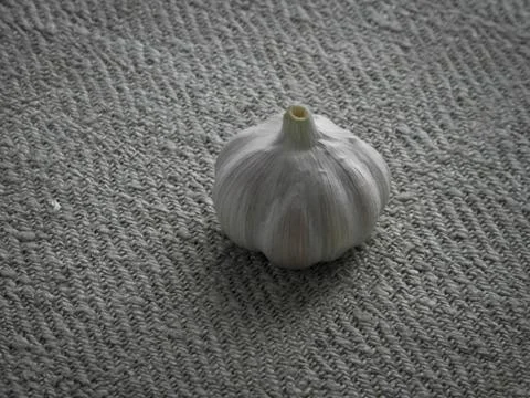 Garlic on the table on a gray tablecloth. Stock Photos