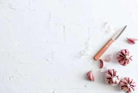 Garlic on a white plaster surface Stock Photos