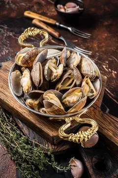 Garlic white wine shells Clams, vongole in a skillet with herbs. Dark background Stock Photos