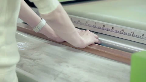 Garment worker hands placing knitted fabric machine roller. Closeup textile. Stock Footage 345887813