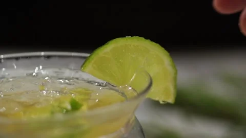 Garnishing a cocktail with a slice of lime Video stock 219564484