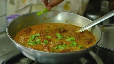 Garnishing with coriander vegetable Kofta curry in kadai which is an Indian Food Stock-Footage 248490737
