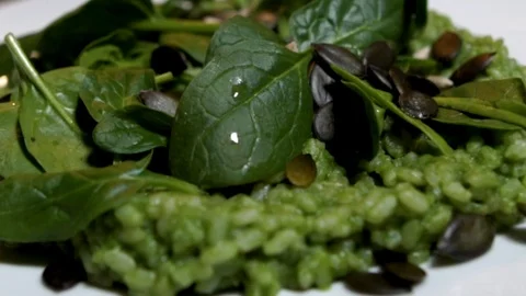 Garnishing green spinach risotto with sunflower and pumpkin seeds, STILL, Stockbeeldmateriaal 123106413
