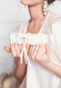 Garter in bride hands Stock Photos