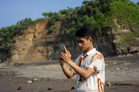 Garut, West Java – 2024, May 22: asian young man is taking photos using a phone Stock Photos
