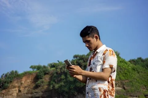 Garut, West Java – 2024, May 22: asian young man is taking photos using a phone Stock Photos