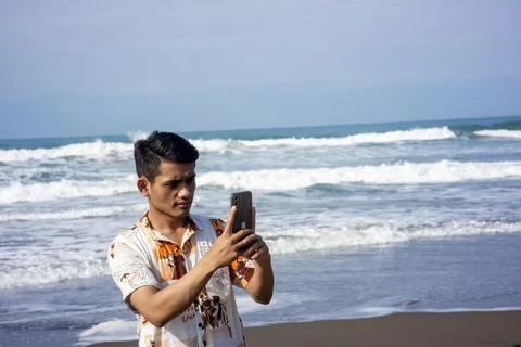 Garut, West Java – 2024, May 22: asian young man is taking photos using a phone Stock Photos